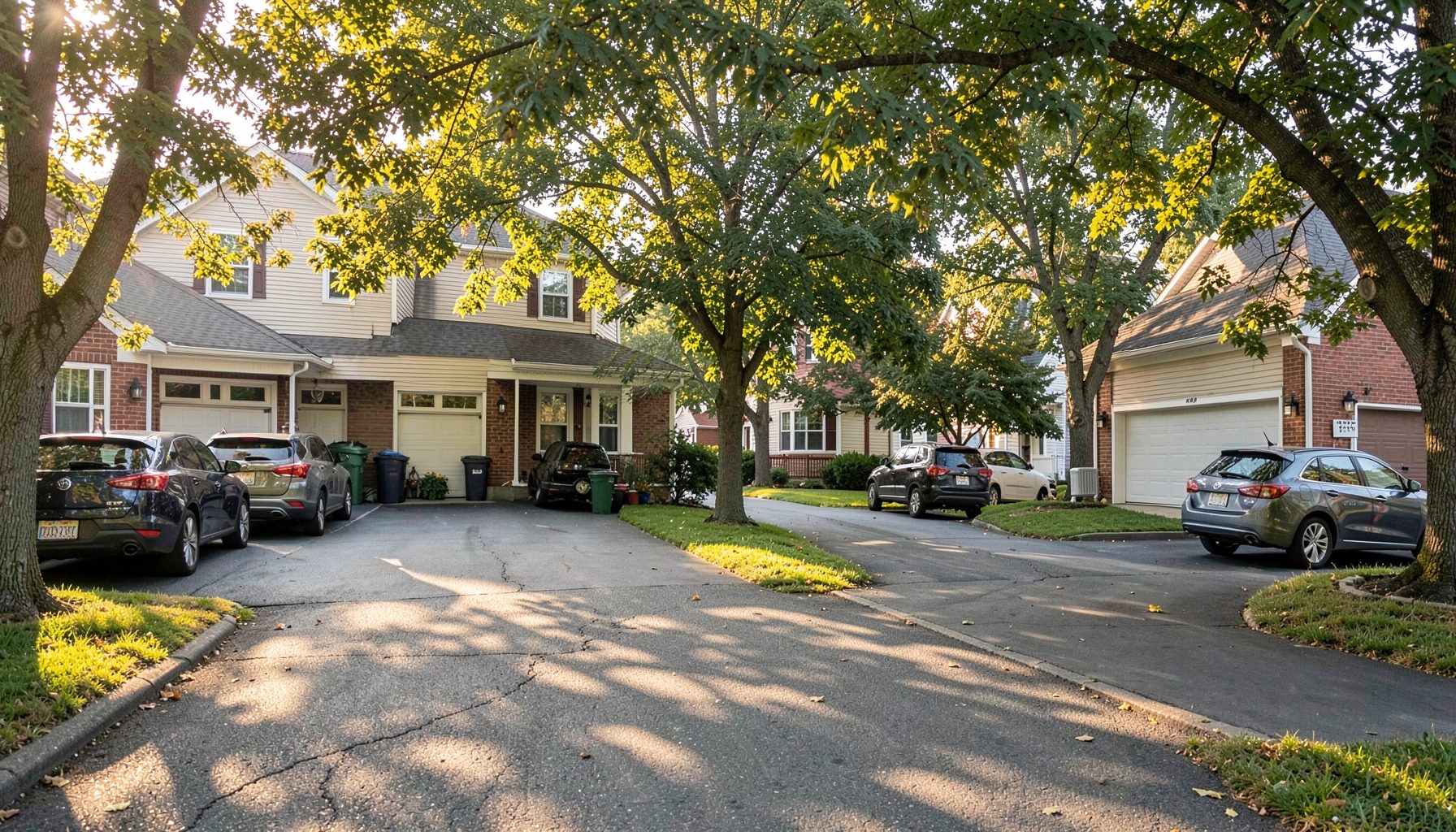 A residential neighborhood in New Jersey with driveways and vehicles, warm afternoon sunlight filtering through trees
